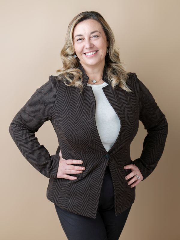 Professionista sorridente con giacca elegante in tessuto a quadretti, ideale per organizzazione **eventi per matrimoni**